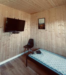 拉达瓦Brzozowa Aleja的一间设有床铺和墙上电视的房间