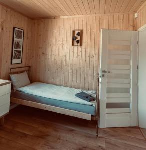 拉达瓦Brzozowa Aleja的卧室配有木墙内的一张床