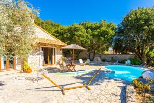 VlachopoulátikaVilla Nionios的一个带游泳池的后院和一个带秋千的房子