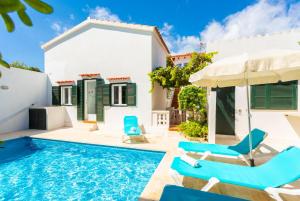 蓬塔普里马Villa Torreta的别墅 - 带游泳池和蓝色椅子