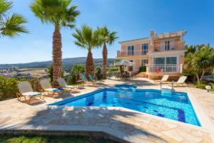 圣特里亚斯Villa Astro的一座别墅,设有游泳池和棕榈树