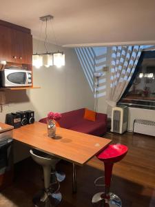 圣地亚哥VR Suite Santiago的厨房配有木桌和红色沙发。