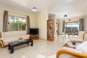 佩亚Villa Solon的客厅配有白色家具和电视