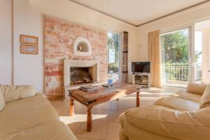 圣特里亚斯Villa Pelagos的客厅配有桌子和壁炉
