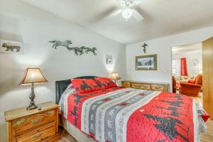 克劳德克罗夫特Charming Cloudcroft Retreat with Deck and Grill!的一间卧室配有一张带红色和黑色棉被的床