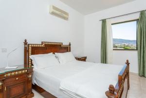 Kato YialiaVilla Olivetta的一间卧室设有一张大床和一个窗户。