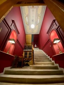 卡拉马塔VASILIKON Hotel 1888 the past is present的带有红色墙壁和天花板的楼梯