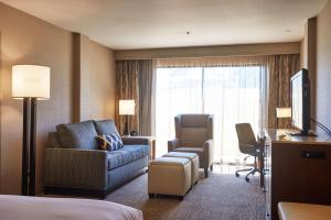弗雷斯诺希尔顿逸林弗雷斯诺会议中心酒店的酒店客房配有床、沙发和椅子