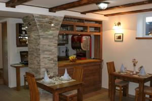 普利特维采湖千年屋住宿加早餐旅馆的用餐室设有2张桌子和石柱