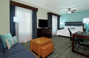 达尼亚滩劳德代尔堡机场邮轮码头希尔顿惠庭套房酒店的配有一张床和一张书桌的酒店客房