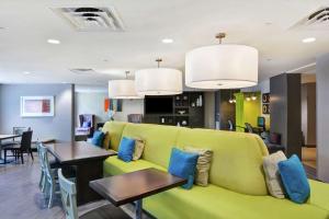 米拉玛米拉玛劳德代尔堡希尔顿欣庭套房酒店的客厅配有绿色沙发和桌子