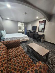 博蒙特Scottish Inn and Suites Beaumont的酒店客房,配有床和沙发