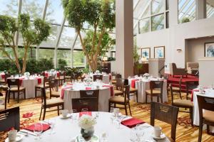 韦恩堡韦恩堡大韦恩希尔顿会议中心酒店的用餐室设有桌椅和窗户。