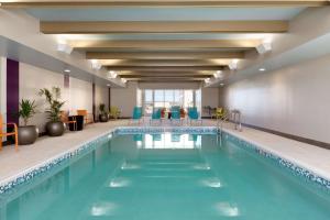 吉列吉列希尔顿欣庭套房酒店的酒店大堂的游泳池,设有蓝色椅子