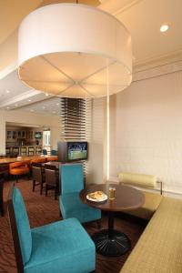 艾尔韦高地希尔顿花园酒店斯波坎机场店的客厅配有桌椅和吊灯。