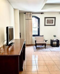 塔里哈Hotel Renacer Tarija的一间带电视和沙发的客厅