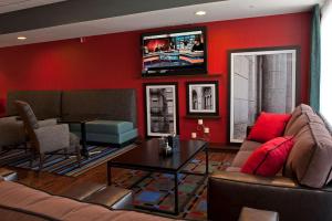 怀俄明大急流城南希尔顿恒庭酒店的客厅配有沙发和墙上的电视