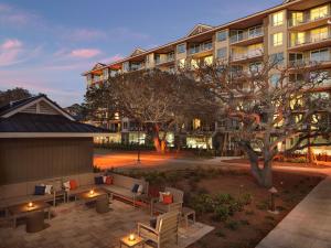 希尔顿黑德岛Hilton Grand Vacations Club Ocean Oak Resort Hilton Head的一座带庭院的建筑,庭院内摆放着家具和一棵树