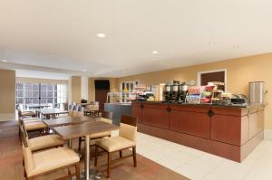 大学城温德姆学院站豪顿套房酒店的一间带桌椅的餐厅和一间厨房