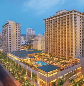 檀香山Embassy Suites by Hilton Waikiki Beach Walk的一座大建筑,在城市前方设有游泳池