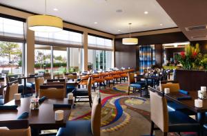 休斯顿美国休斯敦西北广场希尔顿花园酒店的餐厅设有桌椅和窗户。