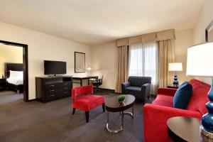 休斯顿美国休斯敦西北广场希尔顿花园酒店的酒店客房设有带红色家具的起居区。