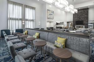 休斯顿Homewood Suites By Hilton Houston Memorial的大堂设有带凳子和桌子的酒吧