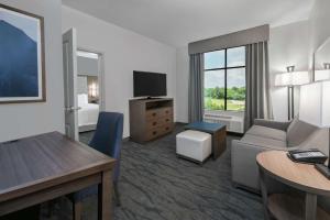 休斯顿Homewood Suites By Hilton Houston Memorial的一间配备有沙发及电视的酒店客房