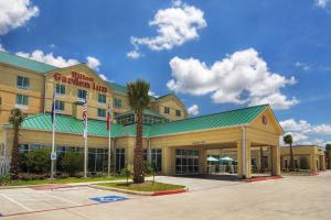 皮尔兰Hilton Garden Inn Houston-Pearland的一座酒店大楼,前面有棕榈树