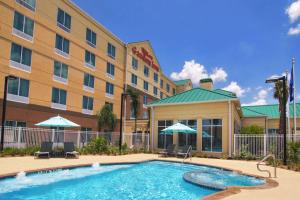 皮尔兰Hilton Garden Inn Houston-Pearland的大楼前设有游泳池的酒店