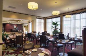 皮尔兰Hilton Garden Inn Houston-Pearland的餐厅设有桌椅和窗户。