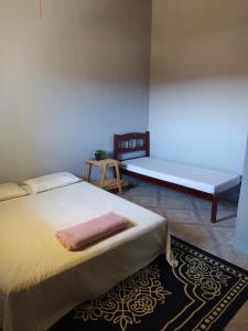 卡瓦坎特Hostel do Cerrado的一间卧室配有两张床,房间设有长凳