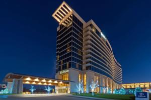 布兰森Hilton Branson Convention Center的一座高大的建筑,晚上有灯