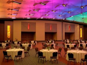 布兰森Hilton Branson Convention Center的宴会厅配有桌椅和紫色照明