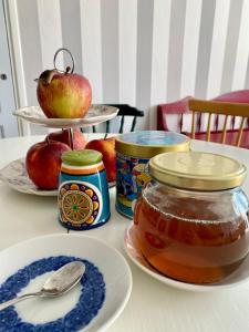 哥德堡Eklinds Rum och Trädgård的一张桌子,上面放苹果和一罐蜂蜜