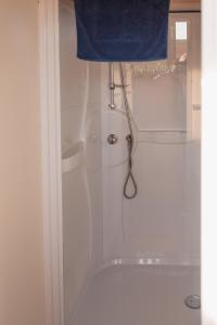 RavelsLandgoed Omorika的白色的淋浴,从门上挂着蓝色的毛巾
