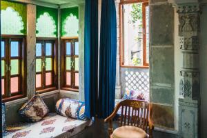 乌代浦拉西旅馆的一间配有沙发的房间和一些窗户