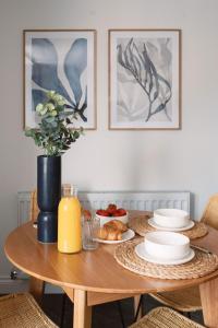 斯托克斯利CRINGLE COTTAGE, The Lanes Cottages, Stokesley的一张木桌,上面放着食物和花瓶