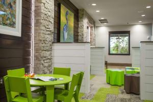 奥兰多Hilton Vacation Club Mystic Dunes Orlando的配有桌子和绿色椅子的房间