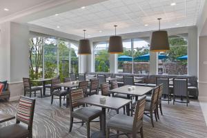 麦迪逊杰克逊-麦迪逊希尔顿花园酒店的用餐室设有桌椅和窗户。