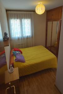 哈卡Jaca Artaso的一间卧室设有黄色的床和窗户。