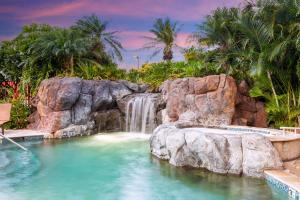 卡波雷卡珀累欧胡岛 - 希尔顿大使馆套房酒店 - 供应免费早餐的度假村内带瀑布的游泳池