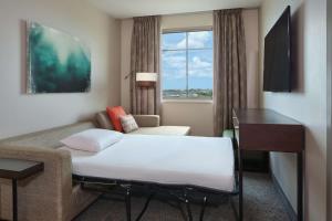 卡波雷卡珀累欧胡岛 - 希尔顿大使馆套房酒店 - 供应免费早餐的酒店客房设有床、沙发和窗户。