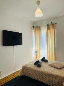 萨卡文Nosso Aconchego的一间卧室配有一张床和一台平面电视