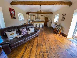 DonyattThe Udderhouse - Udderly Unforgettable Retreat的一间带真皮沙发的客厅和一间厨房