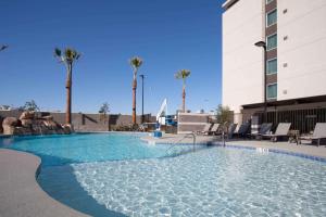 拉斯维加斯拉斯维加斯市中心希尔顿惠庭套房酒店的一座游泳池,位于酒店,设有椅子和棕榈树