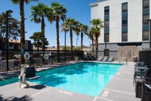 拉斯维加斯汉普顿拉斯维加斯机场套房酒店的一座棕榈树游泳池和一座建筑