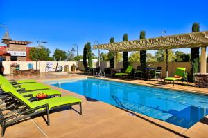 拉斯维加斯拉斯维加斯南汉普顿套房酒店 的一个带绿色躺椅的游泳池和一个庭院