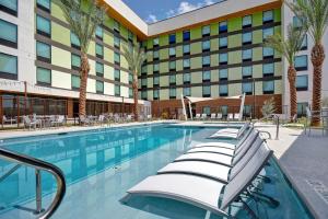 拉斯维加斯Home2 Suites by Hilton Las Vegas Convention Center - No Resort Fee的酒店游泳池设有椅子,酒店大楼