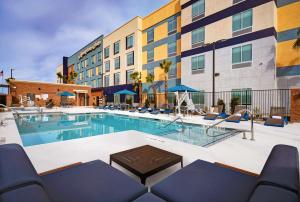 拉斯维加斯Hampton Inn Las Vegas Strip South, NV 89123的一座带椅子的酒店游泳池以及一座建筑
